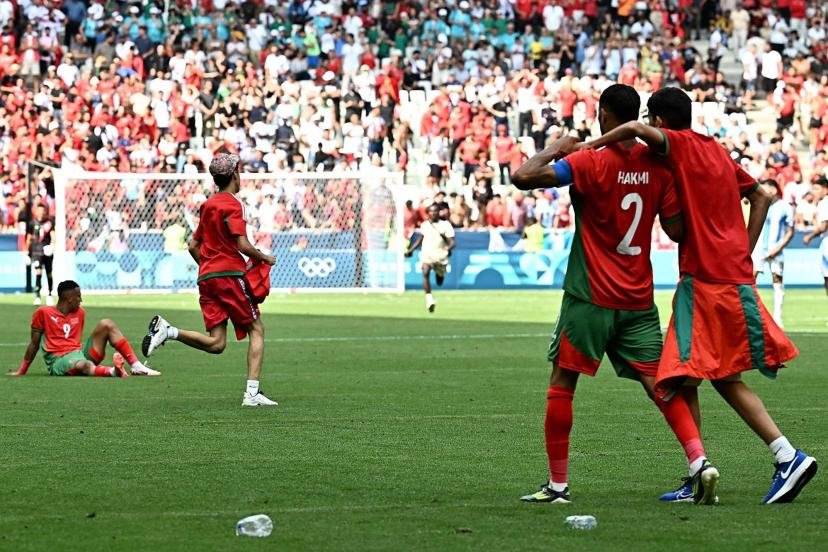 deux joueus de foot marocain qui se prennent dans les bras