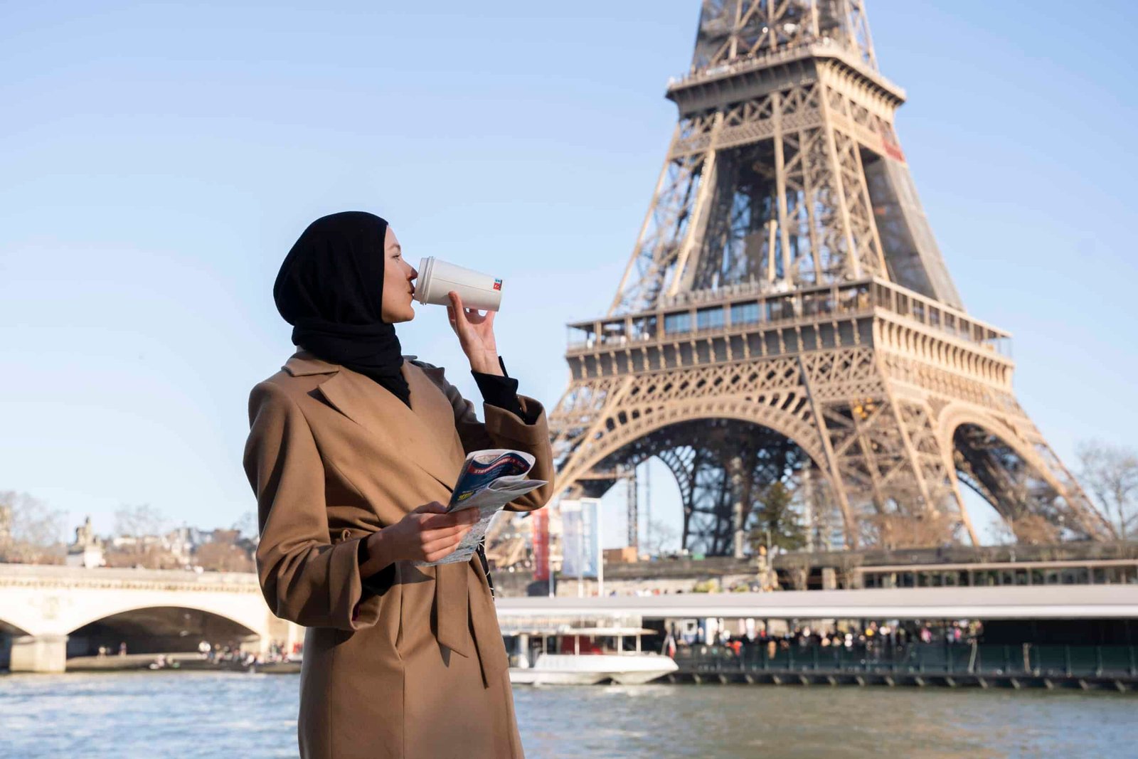 femme marocaine qui boit un café devant la tour eiffel